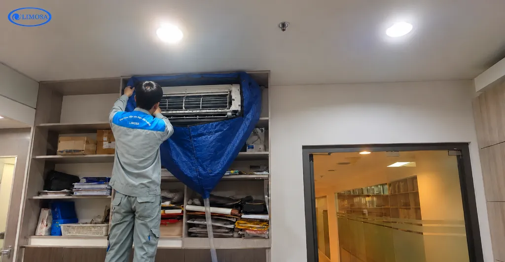 Thợ Limosa tiến hành bọc bạt che chắn khu vực máy lạnh tại văn phòng khu Thới An trước khi vệ sinh